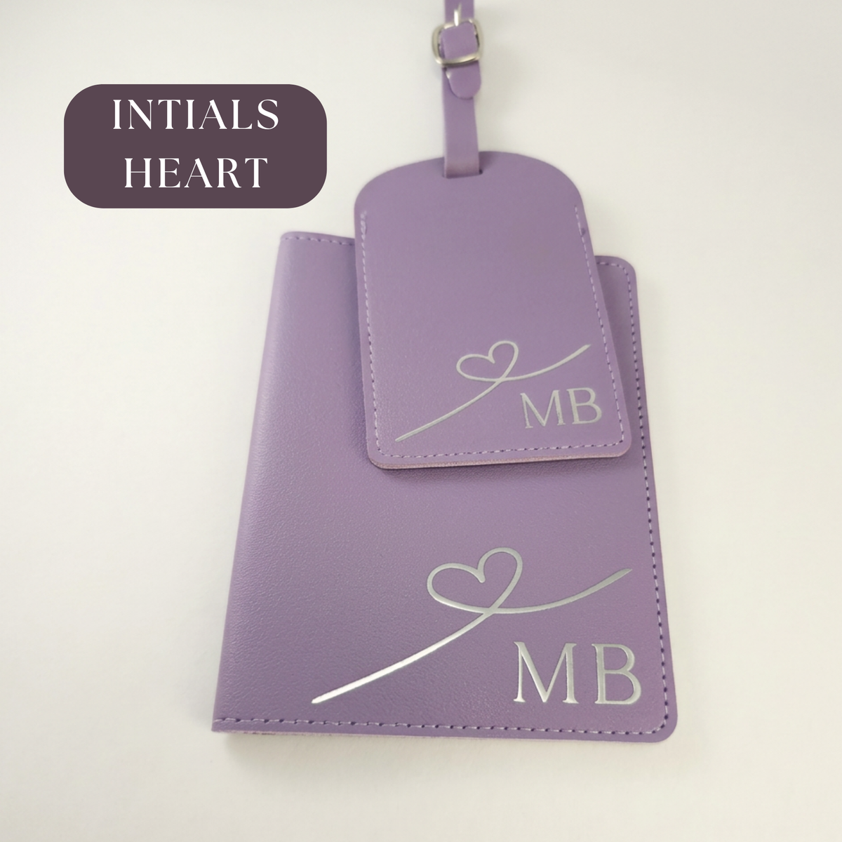Purple passport organiser and matching luggage tag personalised with initials MB and a heart-line design.